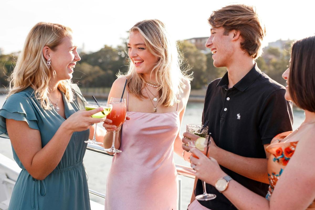 a group of people standing on a boat with drinks
