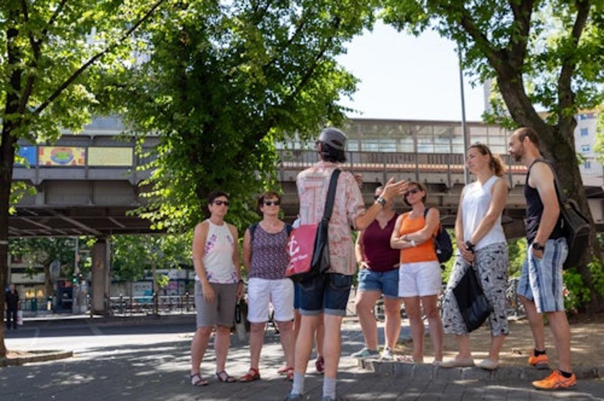 egy csoport ember áll az utca szélén