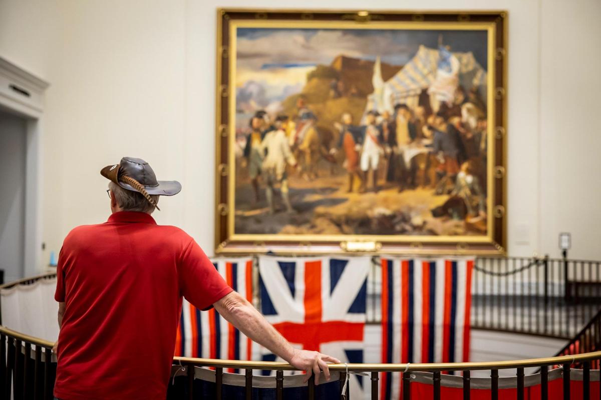 a man looking at a painting in a museum