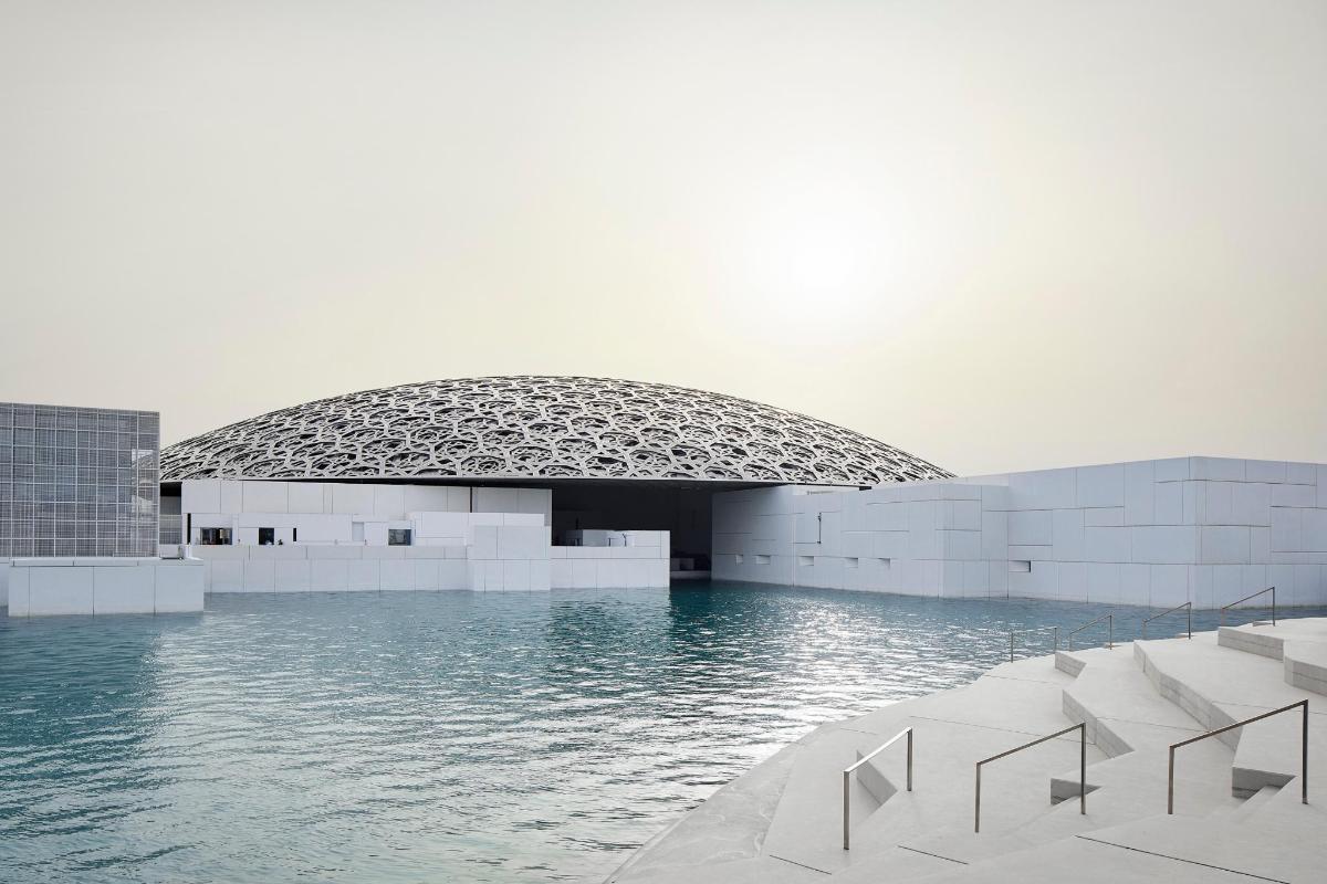 un edificio con una piscina d'acqua di fronte