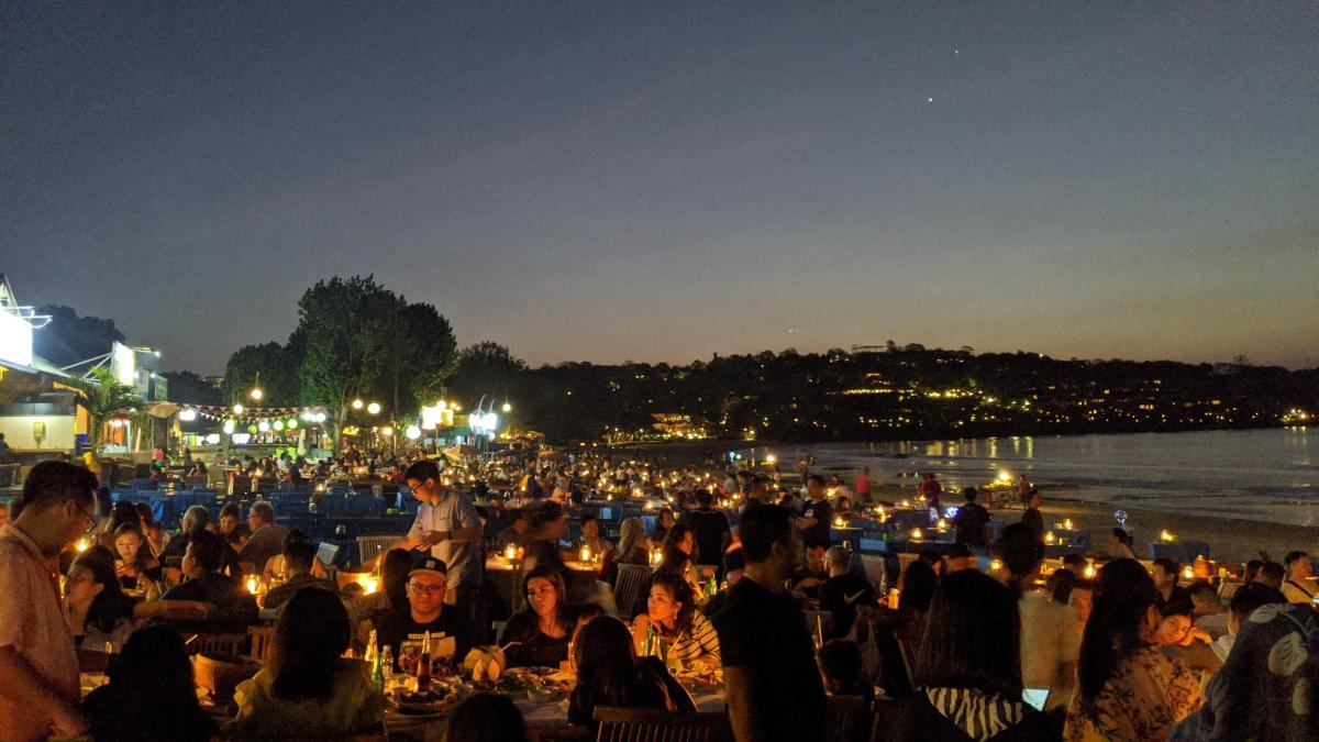 a large group of people sitting at tables with lights