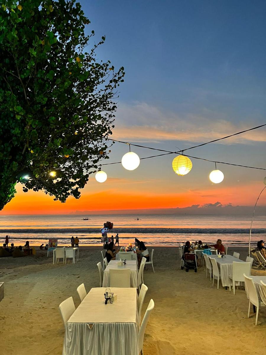 a group of tables on the beach at sunset