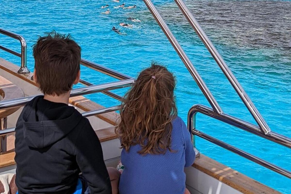 un uomo e una donna seduti su una barca che guardano l'acqua