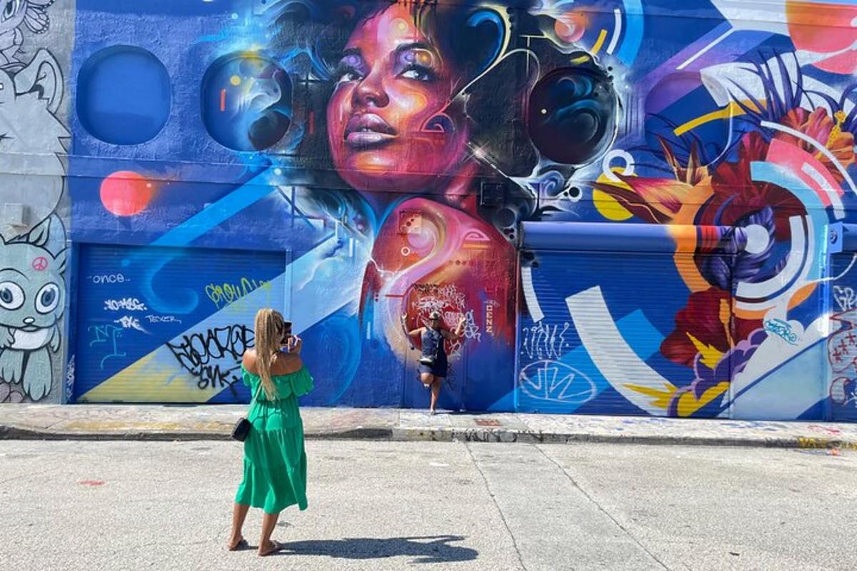 o femeie care fotografiază o pictură murală pe un perete