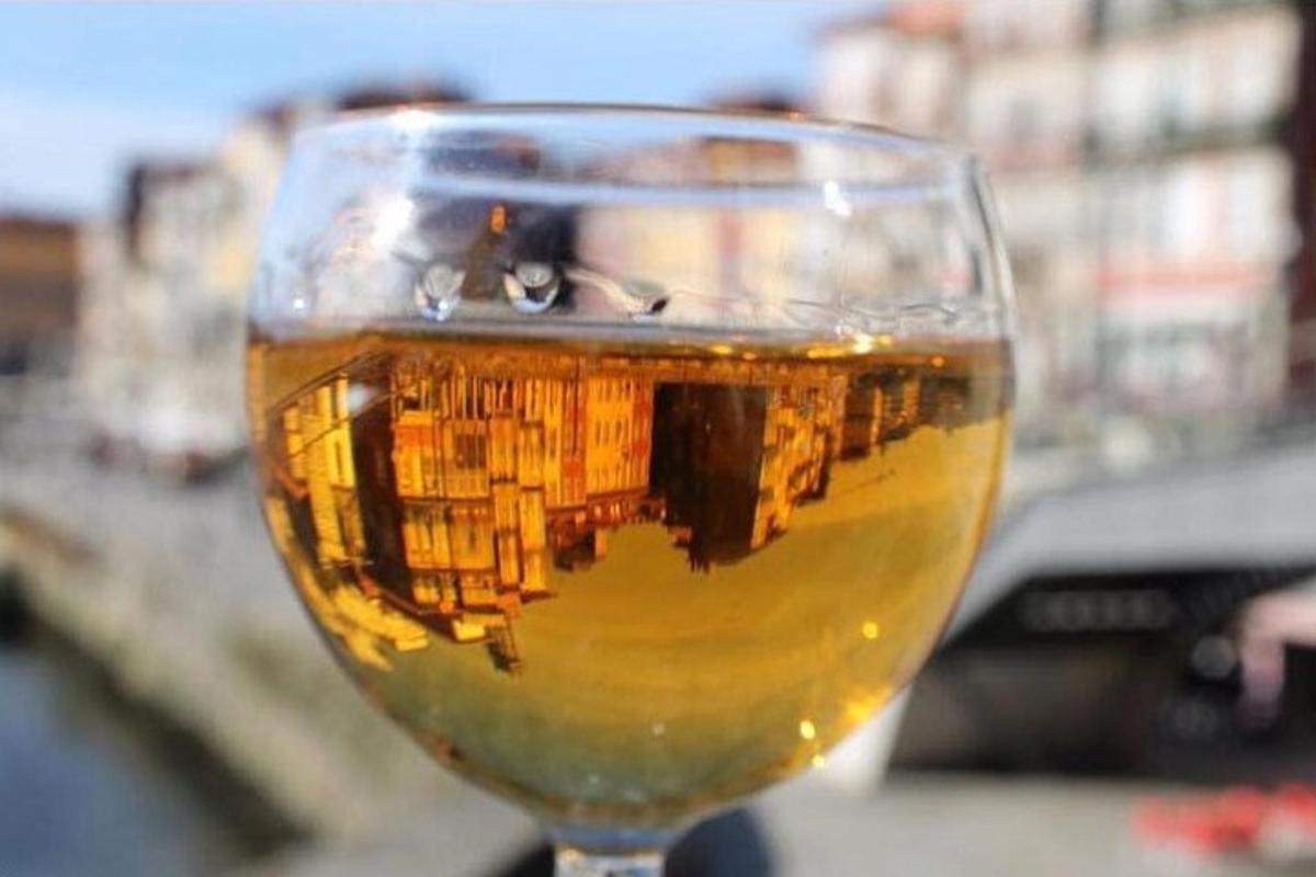 un bicchiere di birra con il riflesso di un edificio al suo interno