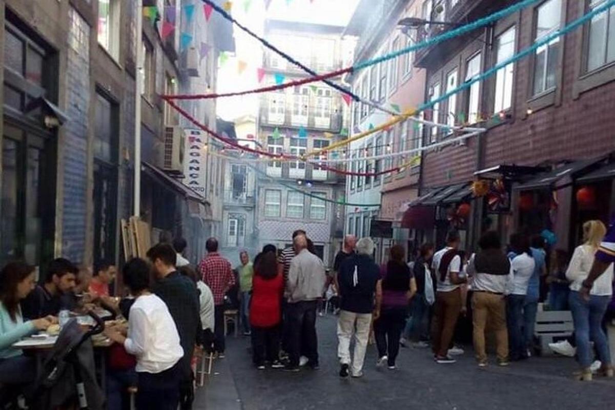 a group of people walking down a street with food vendors