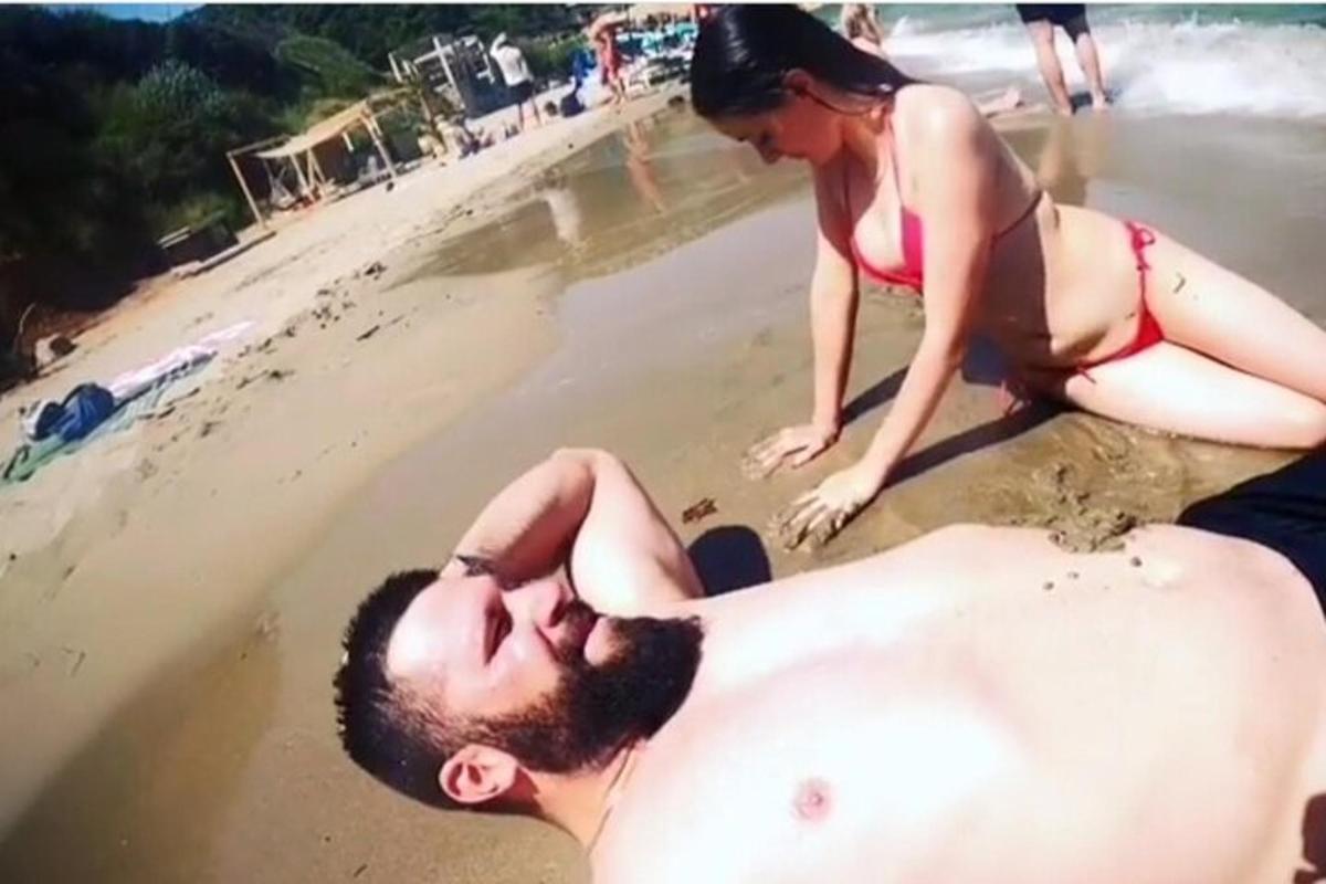 seorang lelaki dan seorang wanita bermain pasir di pantai