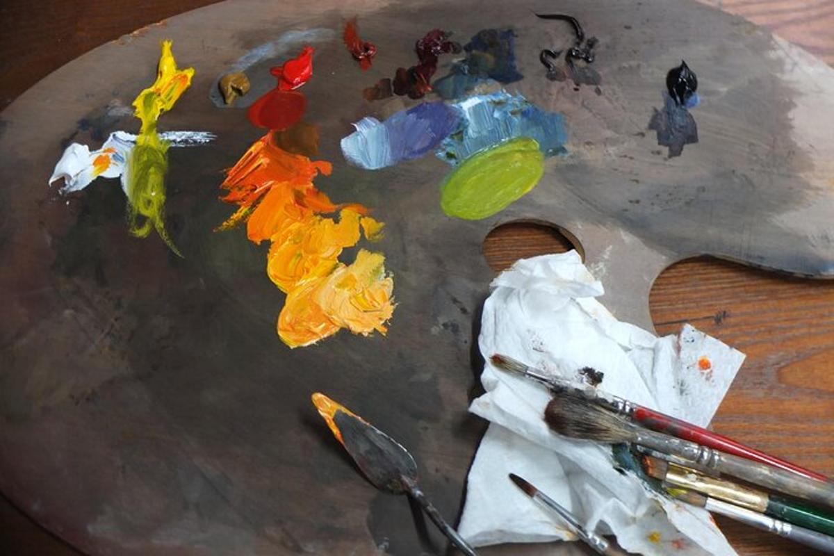 Un cuadro sobre una mesa con pinturas y pinceles.