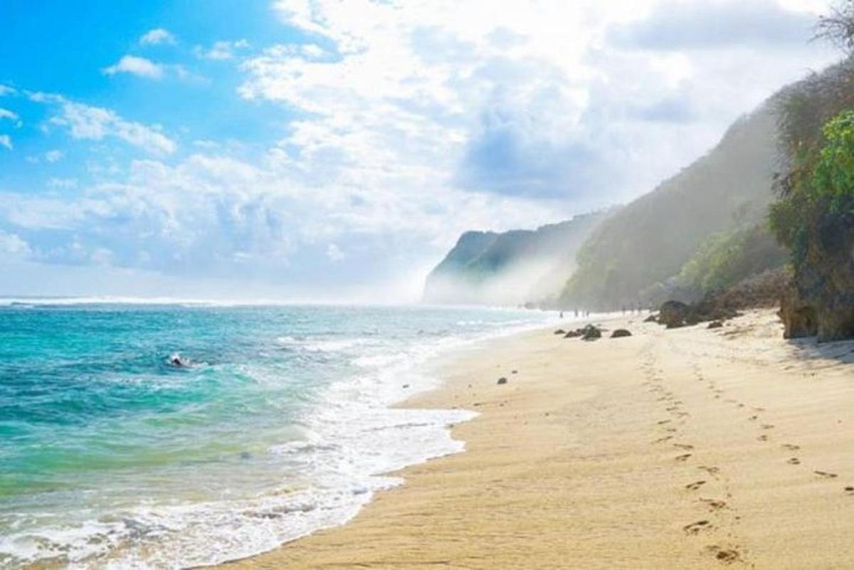 plaža s otiscima stopala u pijesku i oceanu