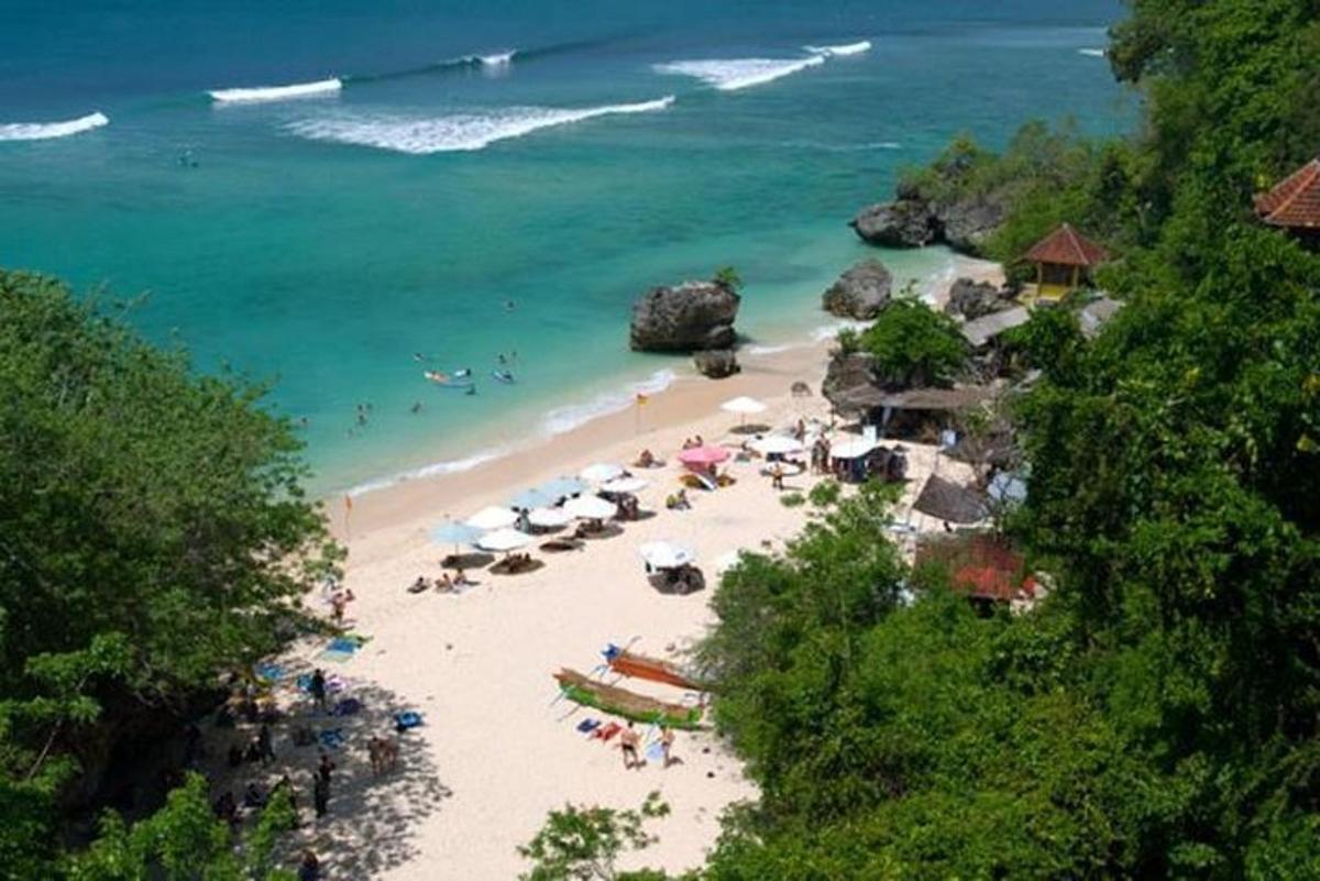plaža sa suncobranima i ljudima u vodi