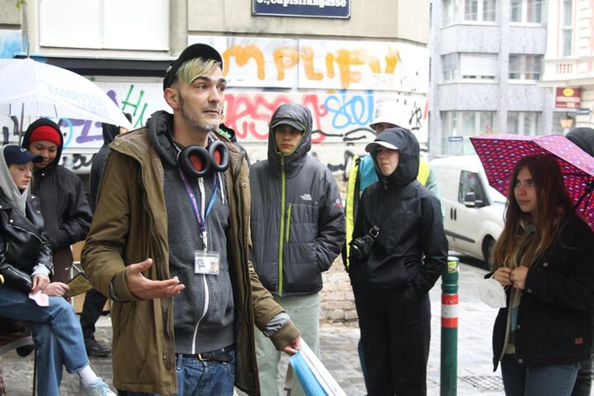 skupina lidí jdoucích po ulici v dešti