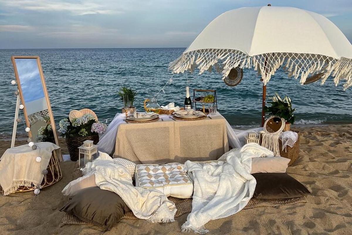 een tafel op het strand met een parasol