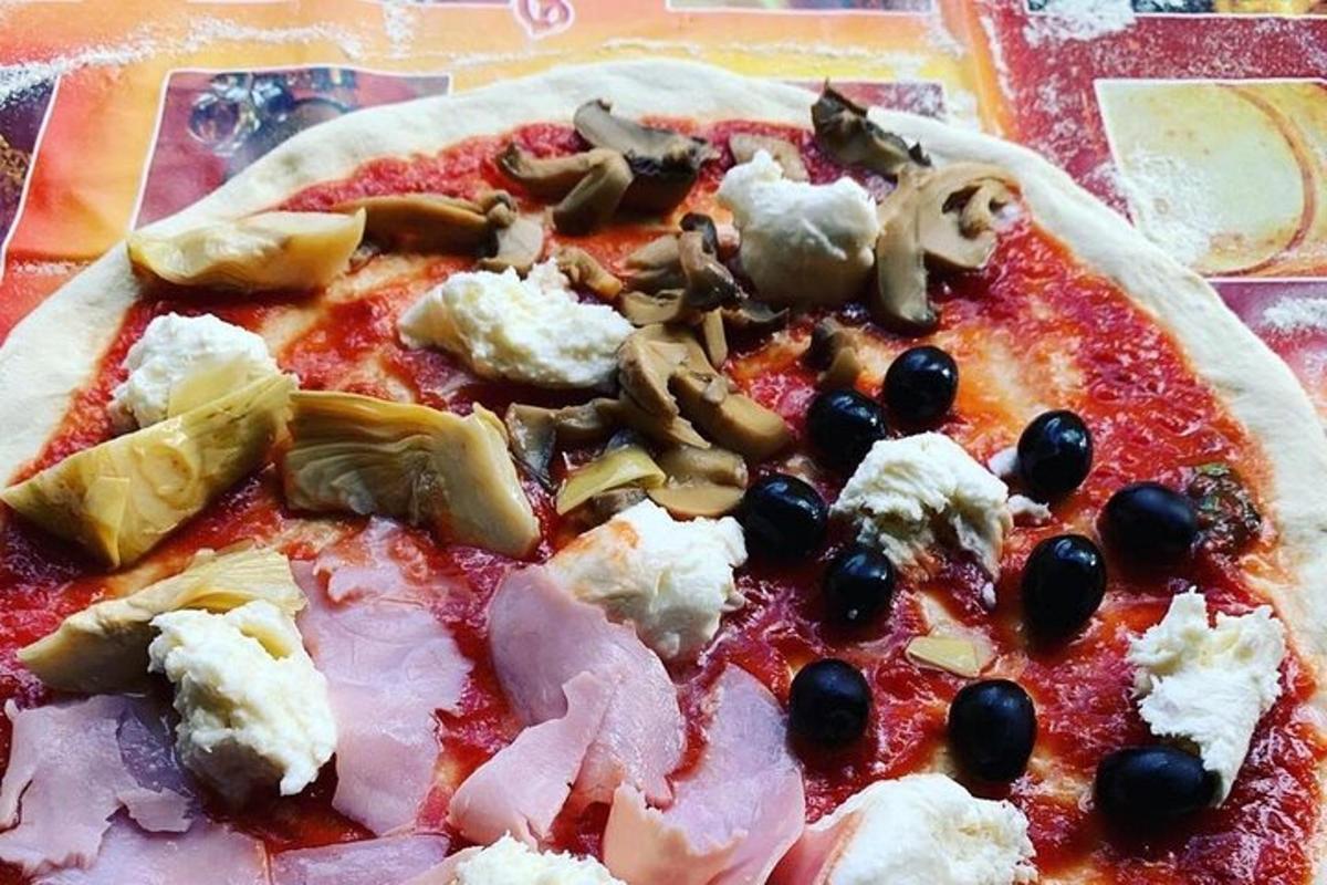 pizza dengan keju dan buah zaitun di atas meja