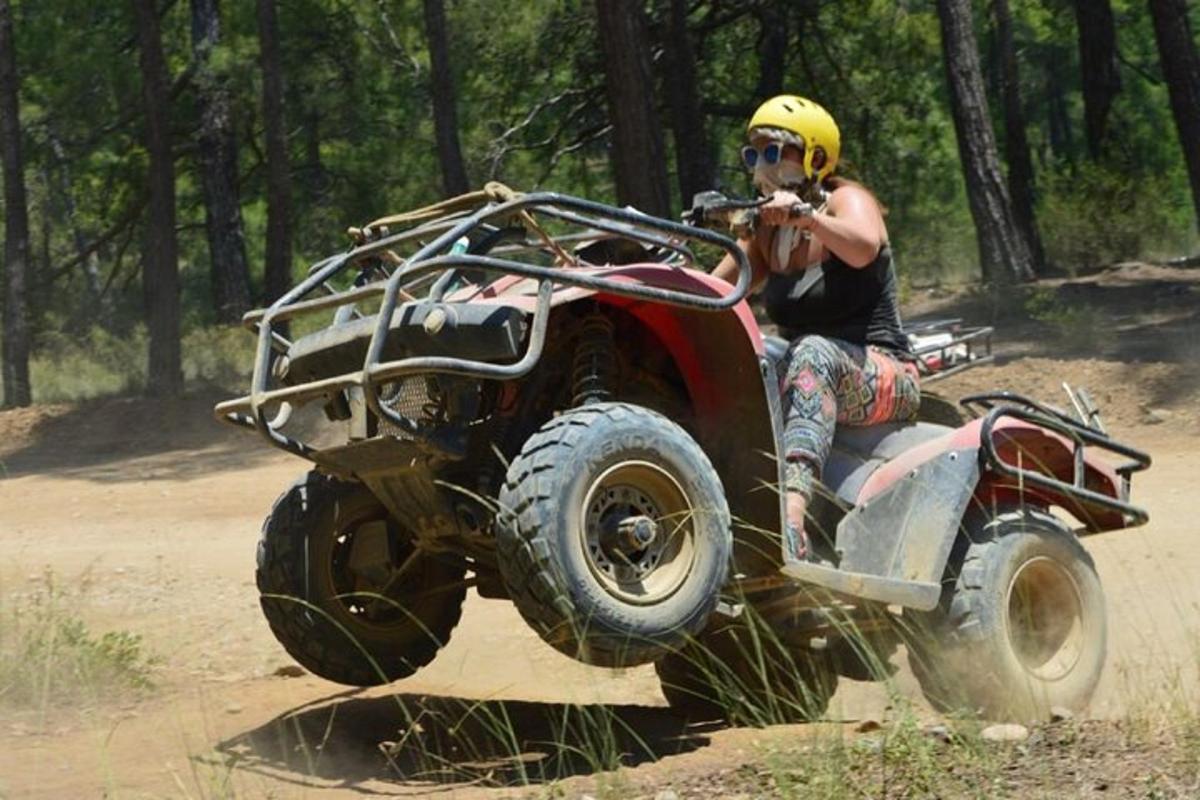 una persona que conduce un quad por un camino de tierra