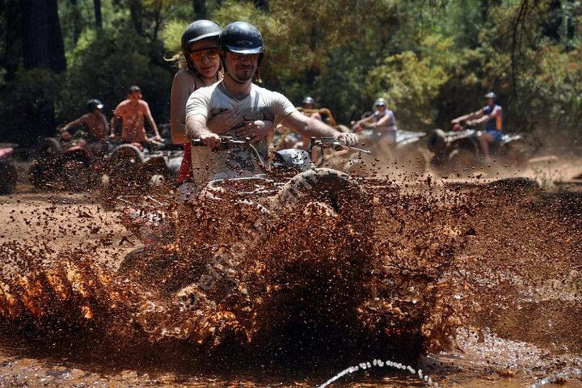 Un grupo de personas viajando en una motocicleta todoterreno en el barro.