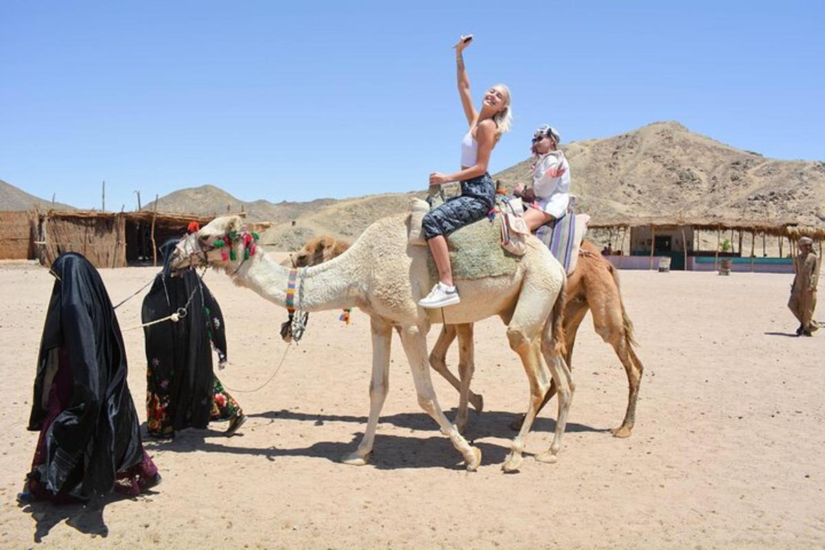 due persone a cavallo di un cammello nel deserto