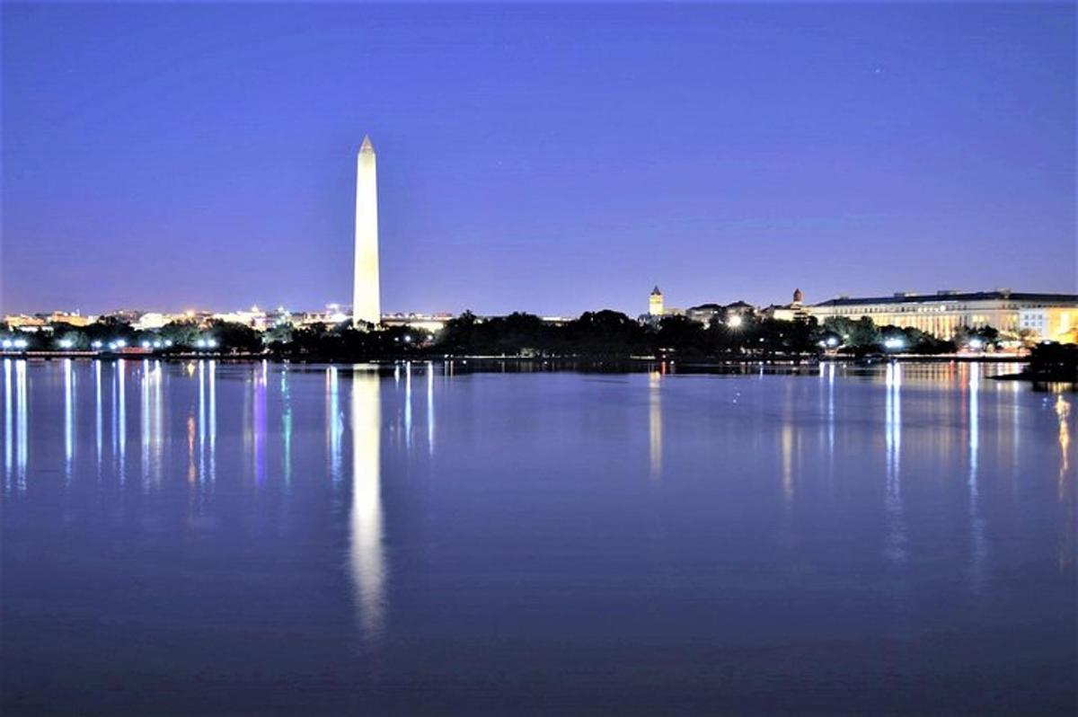 Una gran masa de agua con el monumento a Washington de noche.