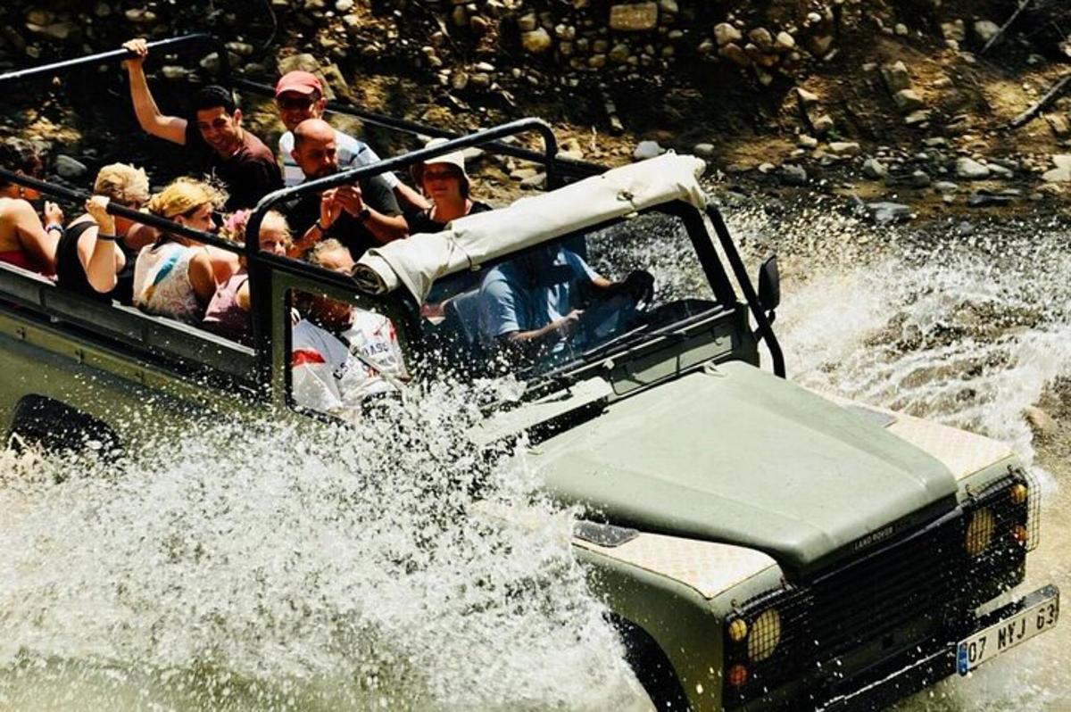 một nhóm người đang ngồi ở phía sau xe jeep dưới nước