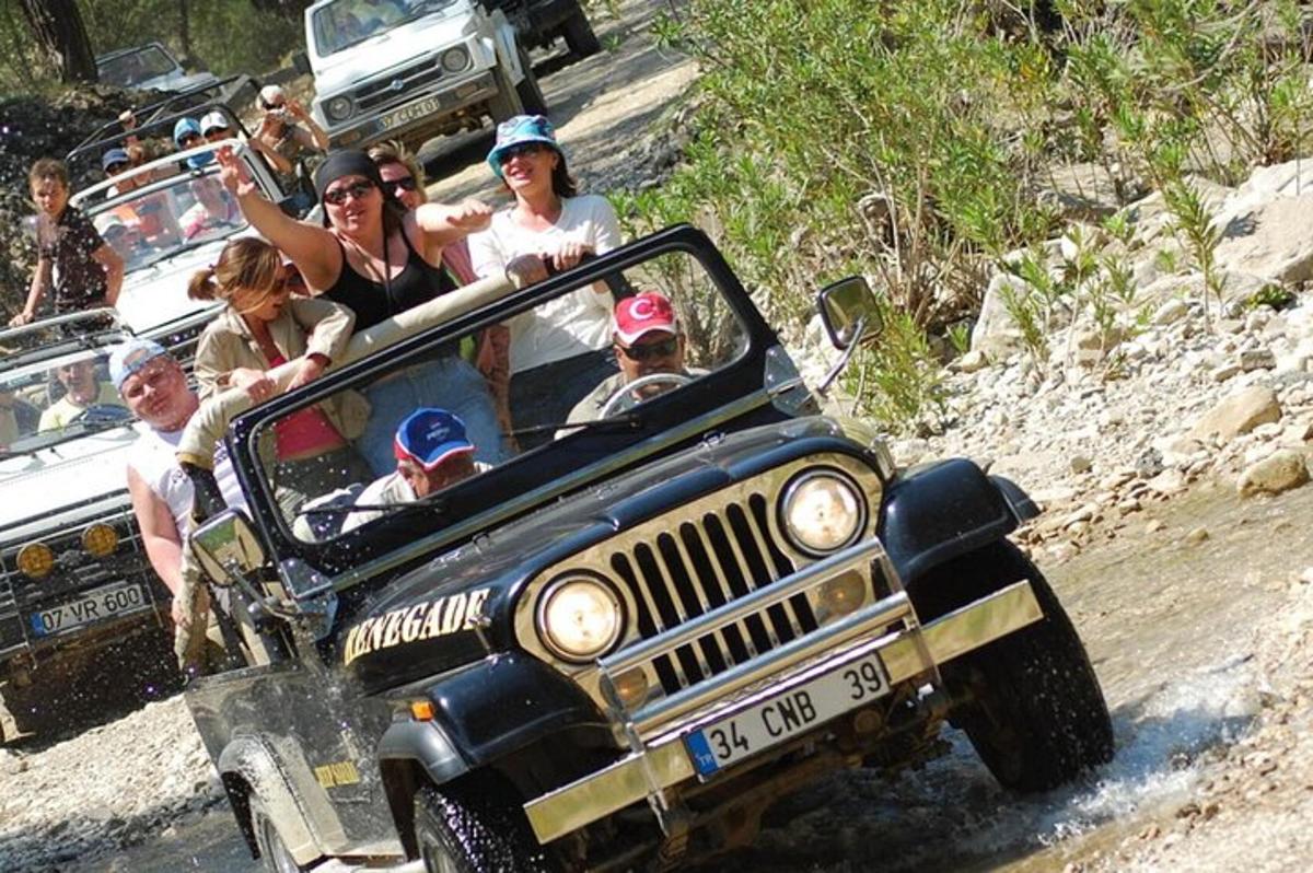 một nhóm người trên xe jeep trên một con đường đất