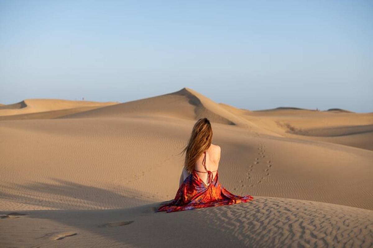 una mujer con un vestido rojo en el desierto