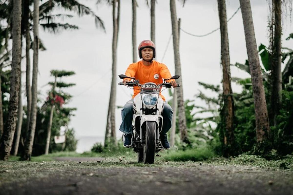 Un hombre que conduce una motocicleta por un camino de tierra