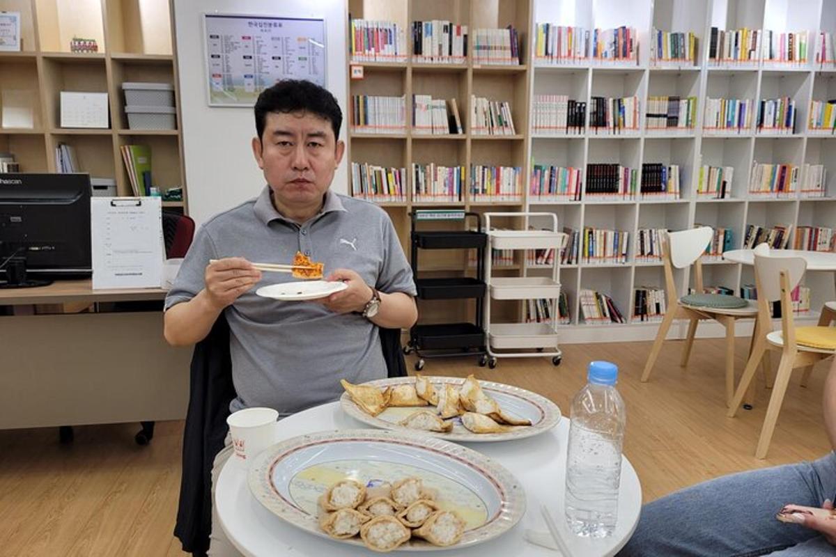 un uomo che mangia cibo seduto a un tavolo con due piatti di cibo