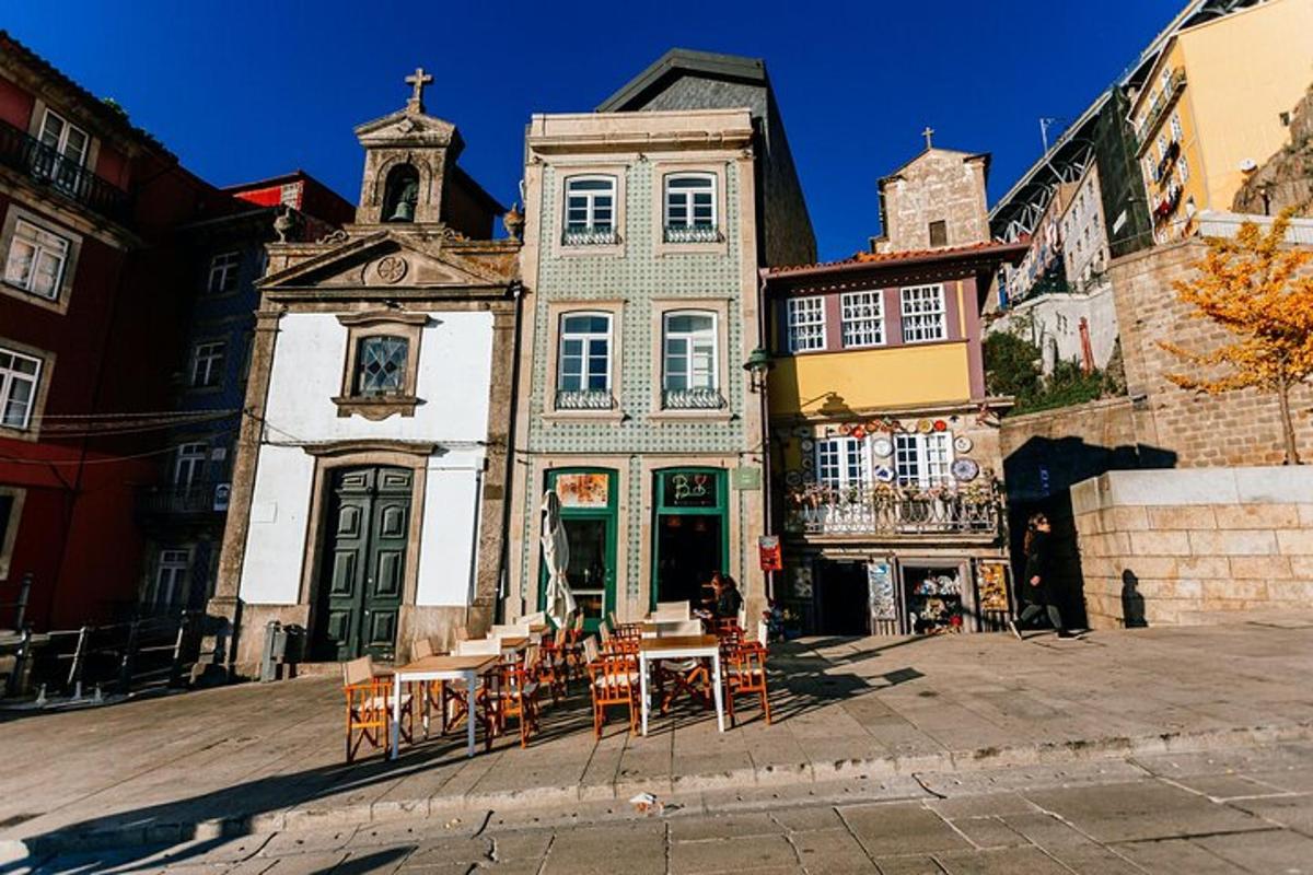 an old building with tables and chairs in front of it