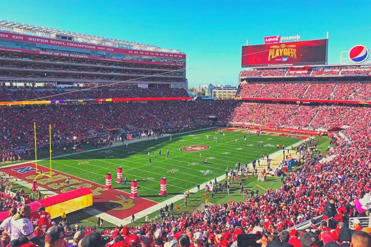 a crowd of people watching a football game in a stadium