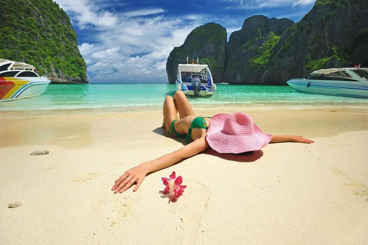 a woman in a pink hat laying on a beach