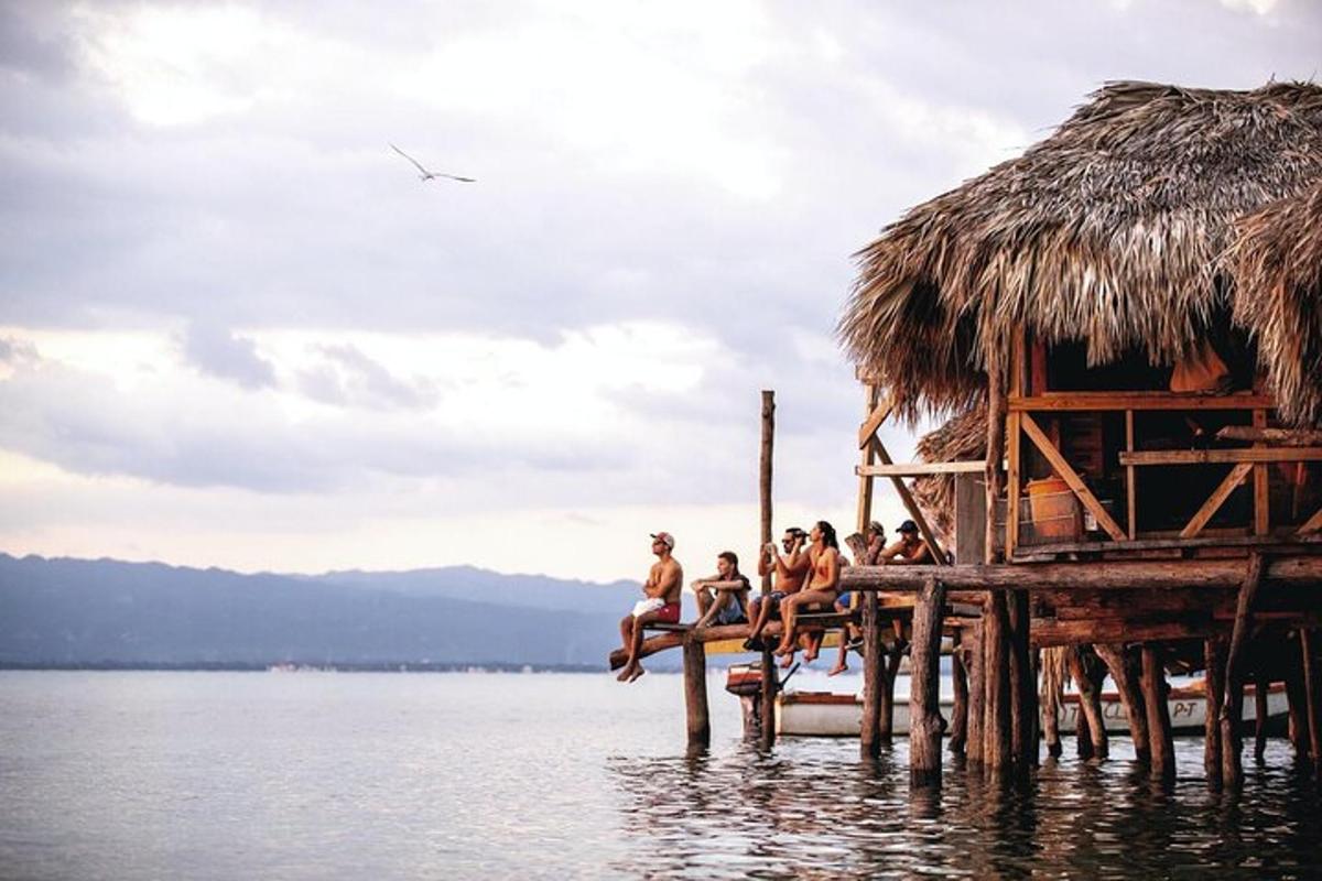 um grupo de pessoas sentadas em uma doca na água