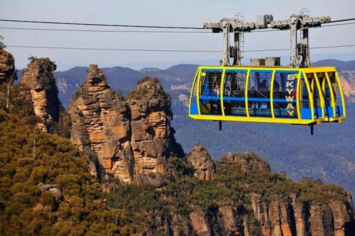 a cable car flying over the blue mountains