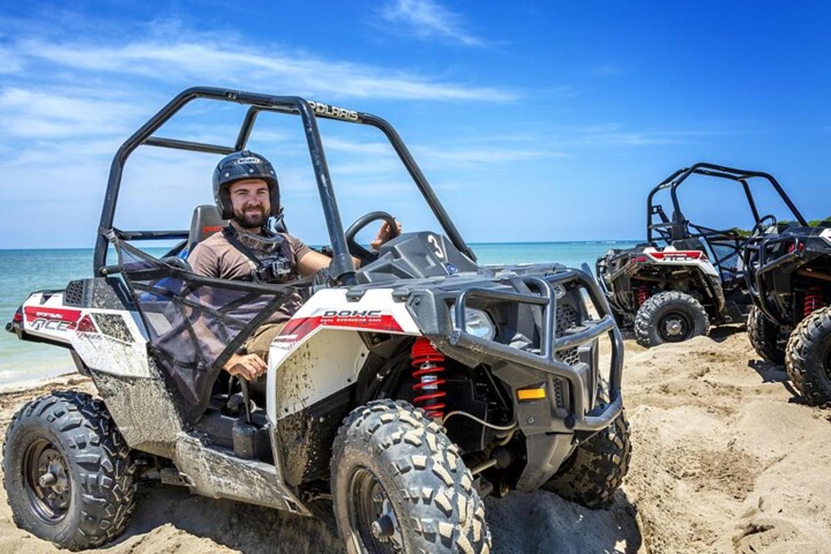 ein Mann sitzt in einem Geländefahrzeug am Strand