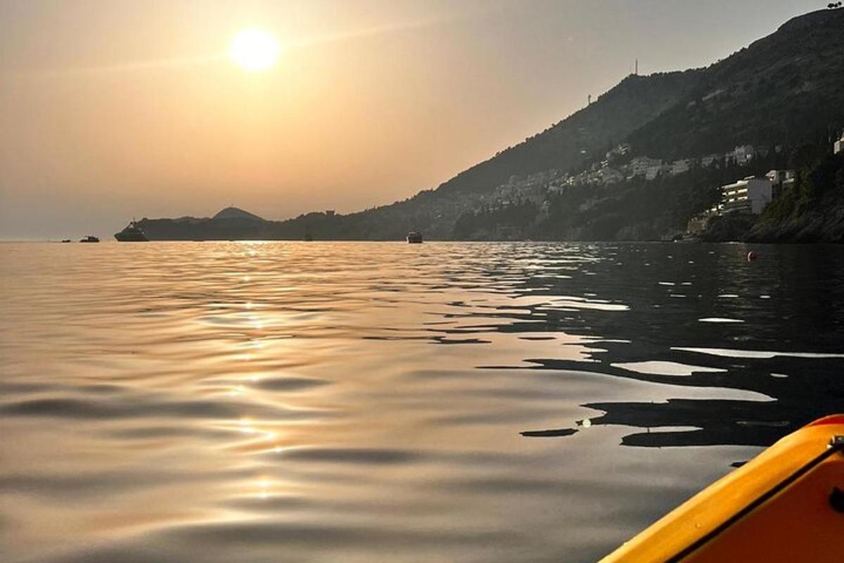 una barca su un lago con il sole che tramonta