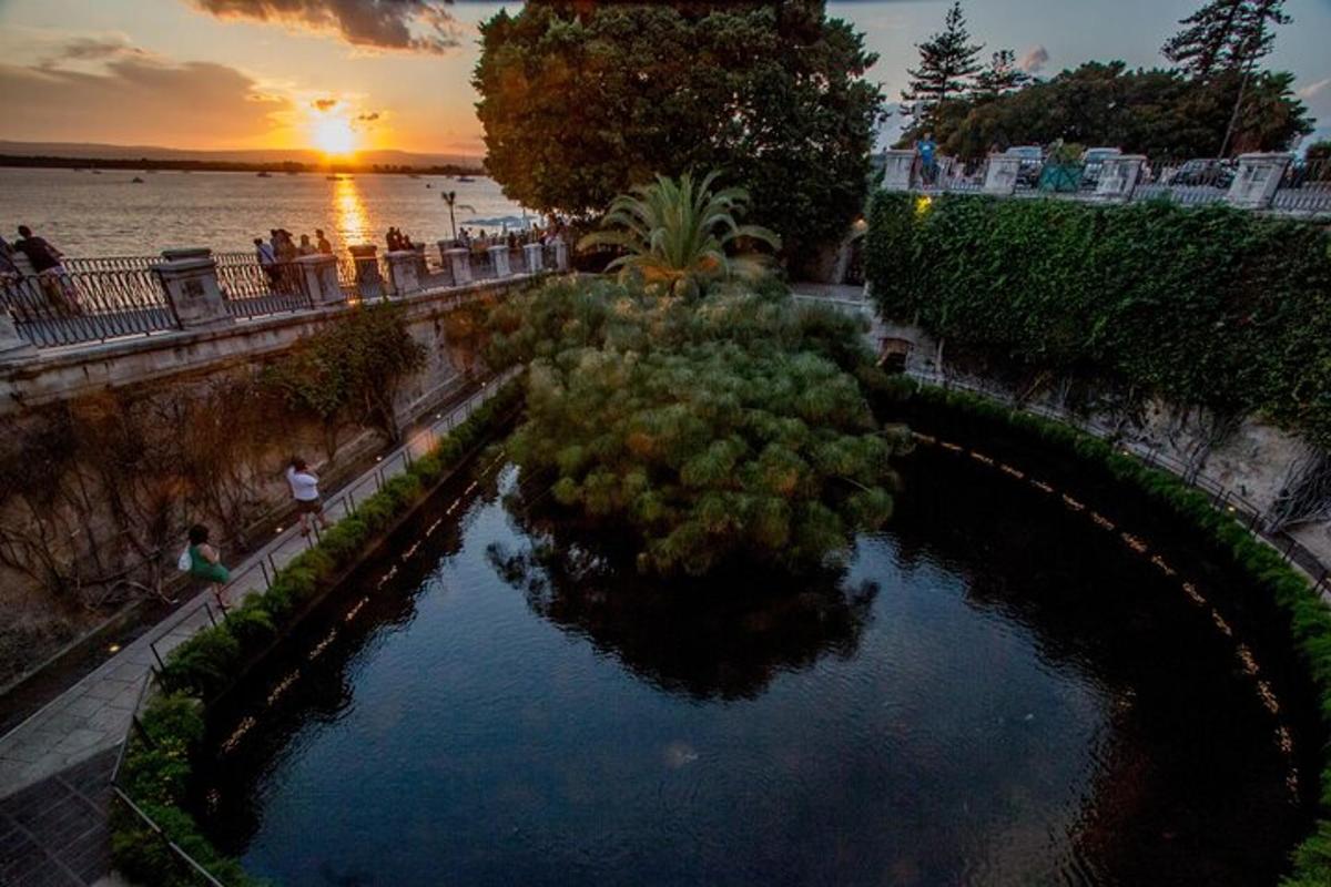 a view of a pool of water with the sunset in the background