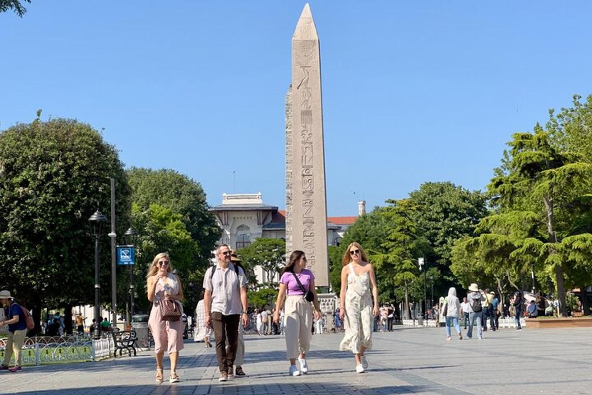 egy csoport ember sétál az obeliszk előtt