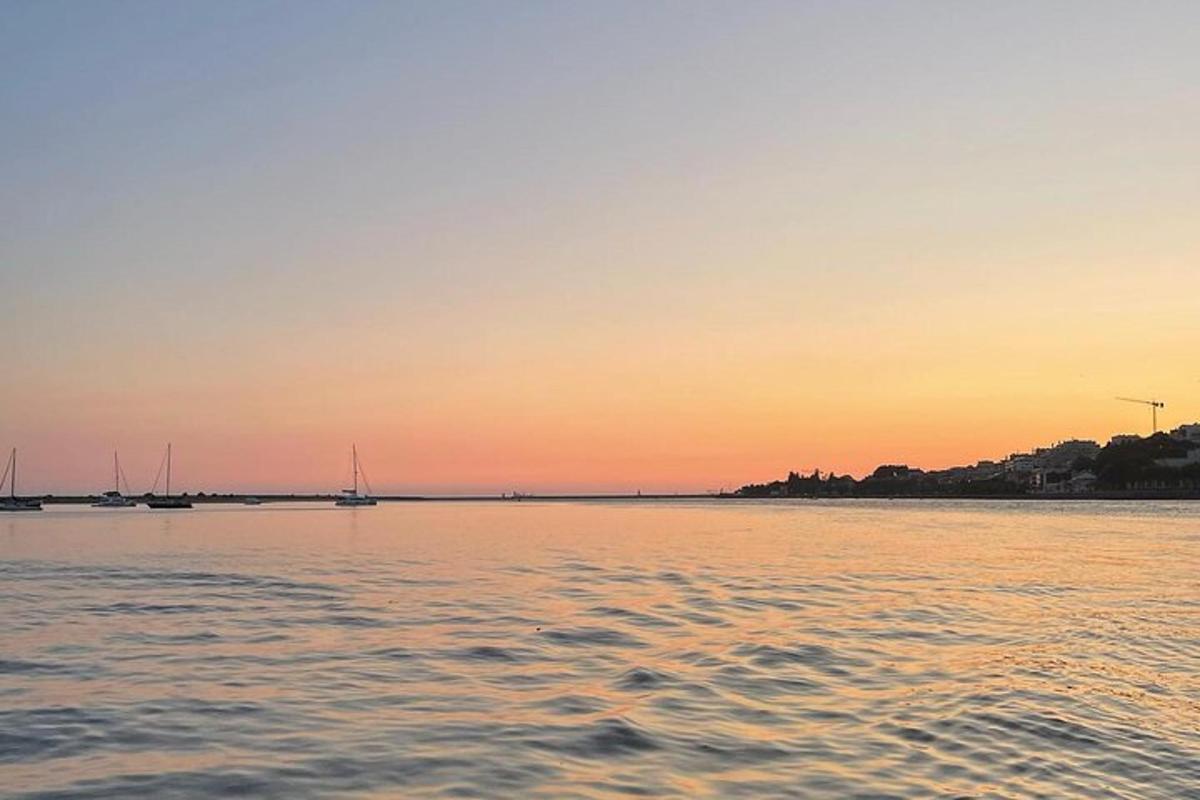 Una puesta de sol sobre un cuerpo de agua con barcos.