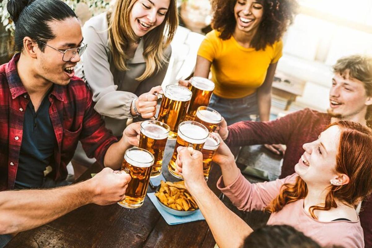 skupina lidí sedících kolem stolu a pijících pivo