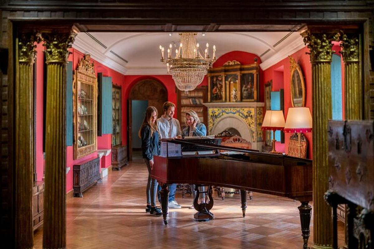 a group of people standing in a room with a piano