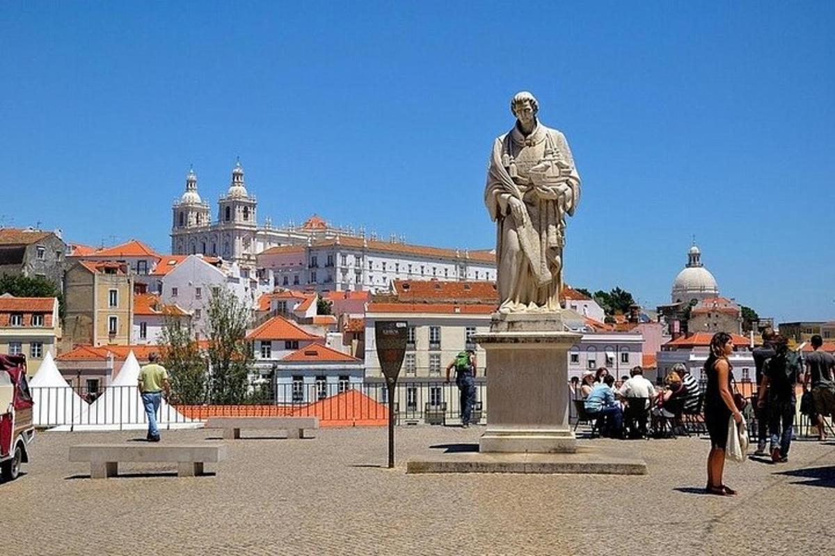 uma estátua de um homem em pé em frente a uma cidade