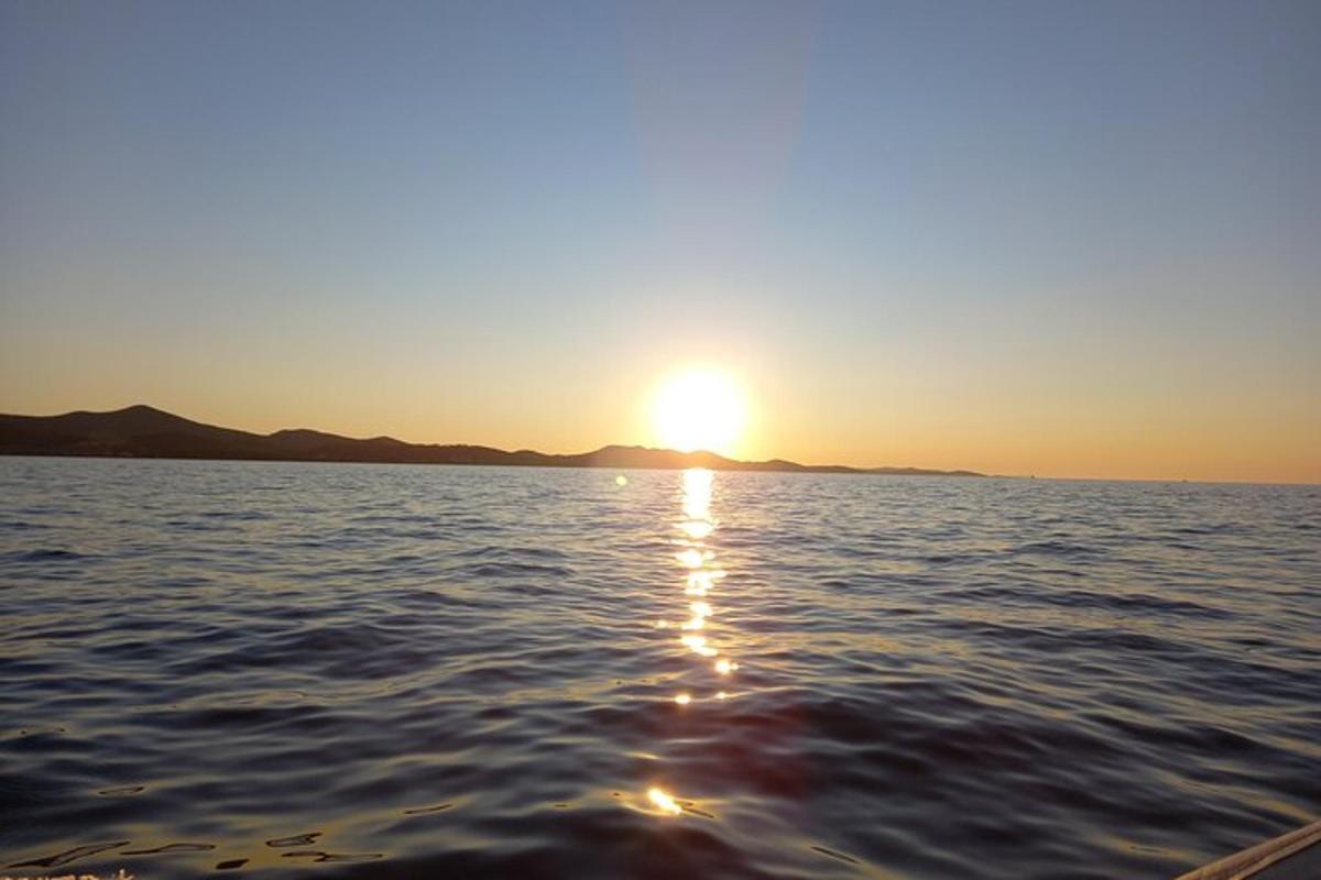 ένα ηλιοβασίλεμα στο νερό με τη δύση του ηλίου