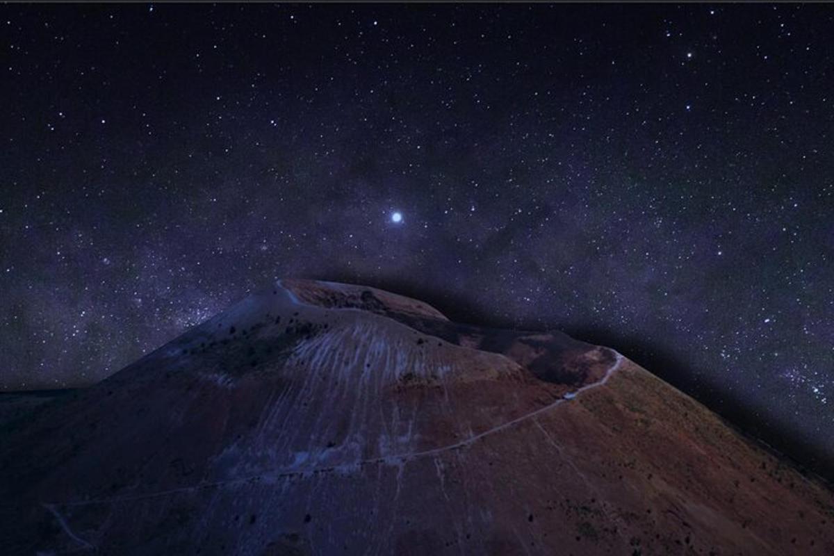 una montaña de noche con un cielo estrellado