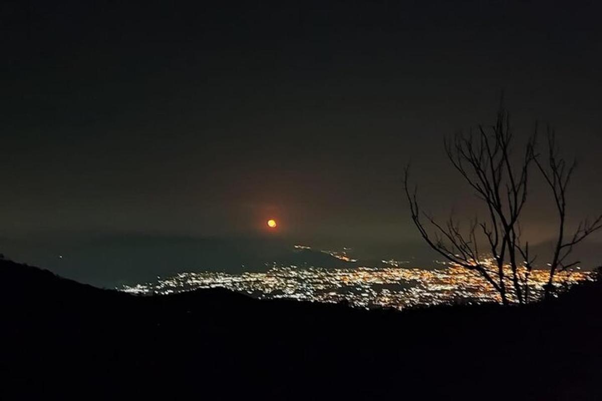 Una vista de una ciudad de noche con la luna.