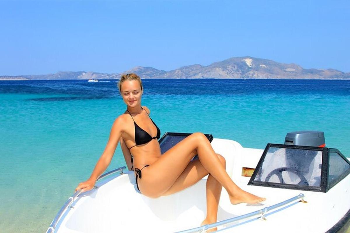 una donna in bikini seduta sulla parte anteriore di una barca