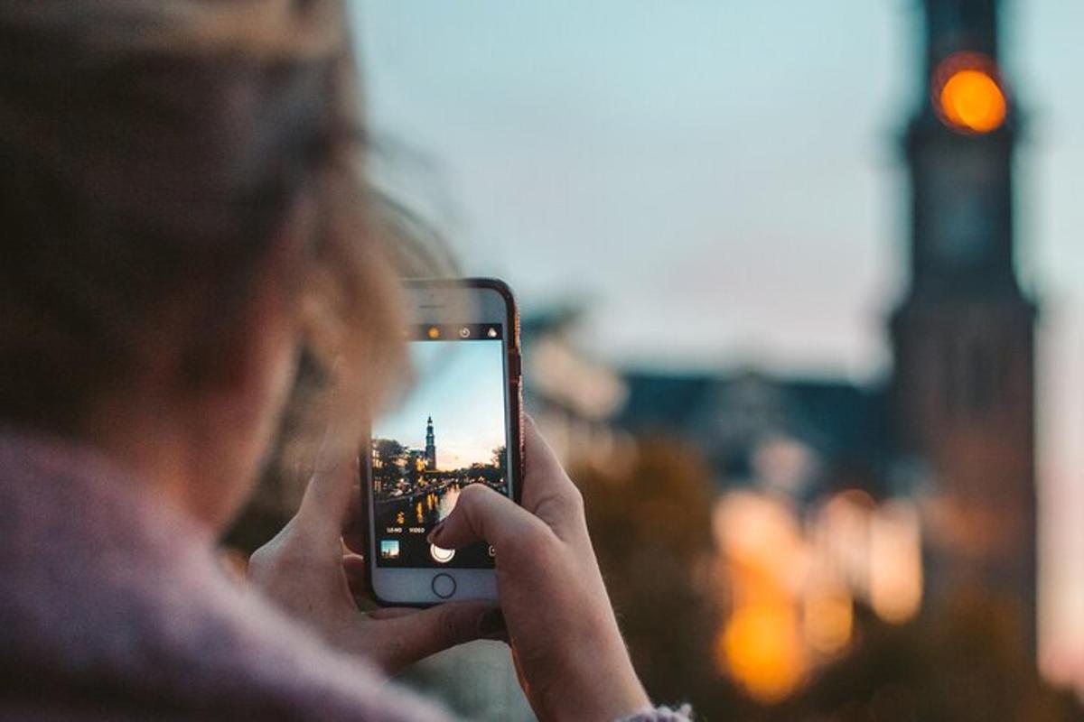 žena fotící město mobilním telefonem