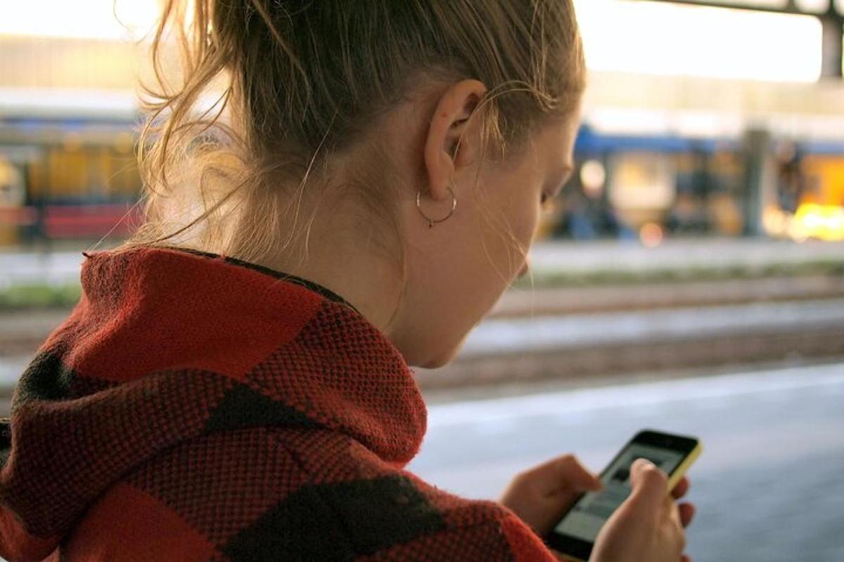 žena se dívá na svůj mobilní telefon