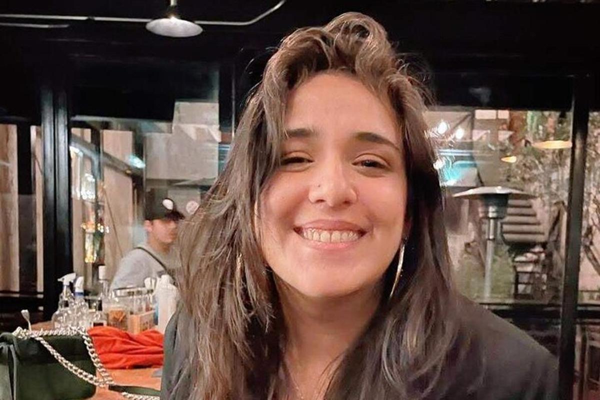 Žena se usmívá do kamery v restauraci