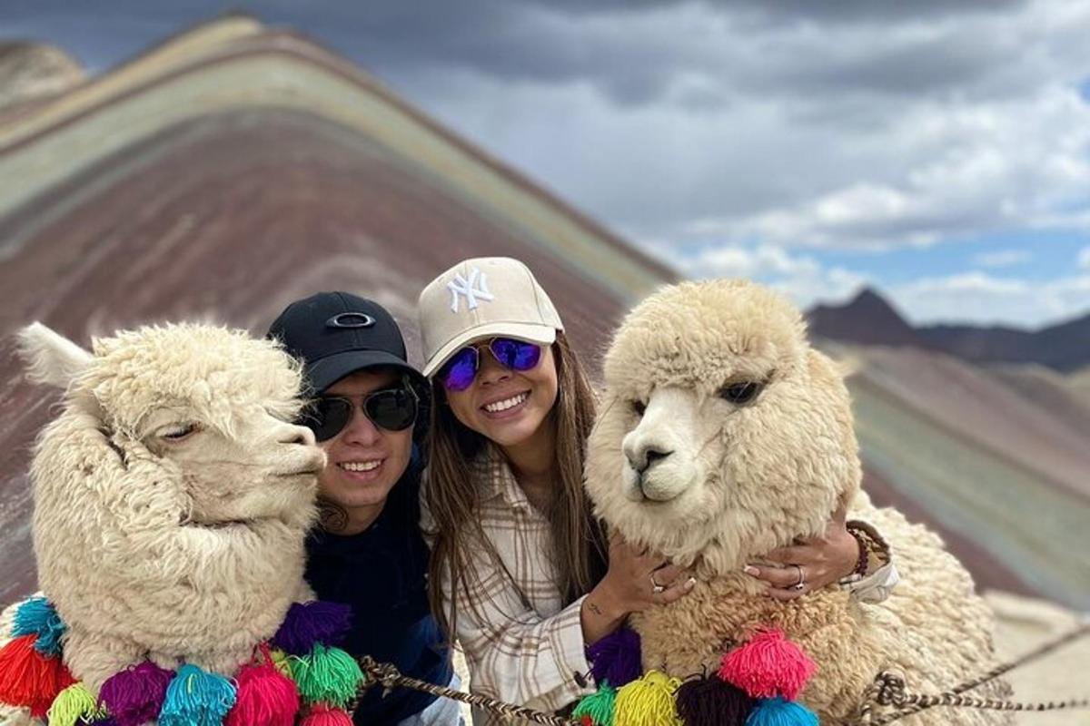 Dos mujeres posando para una foto con dos ovejas