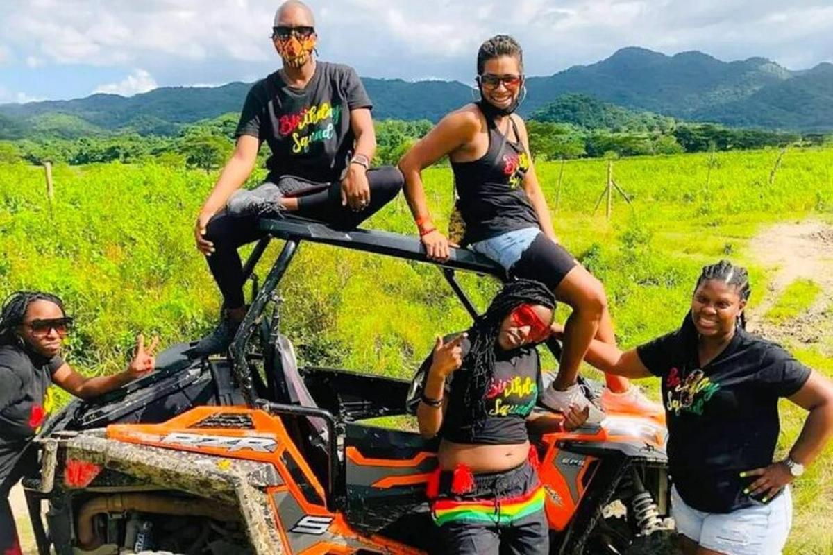 Un grupo de personas sentadas en la parte trasera de un vehículo todo terreno.