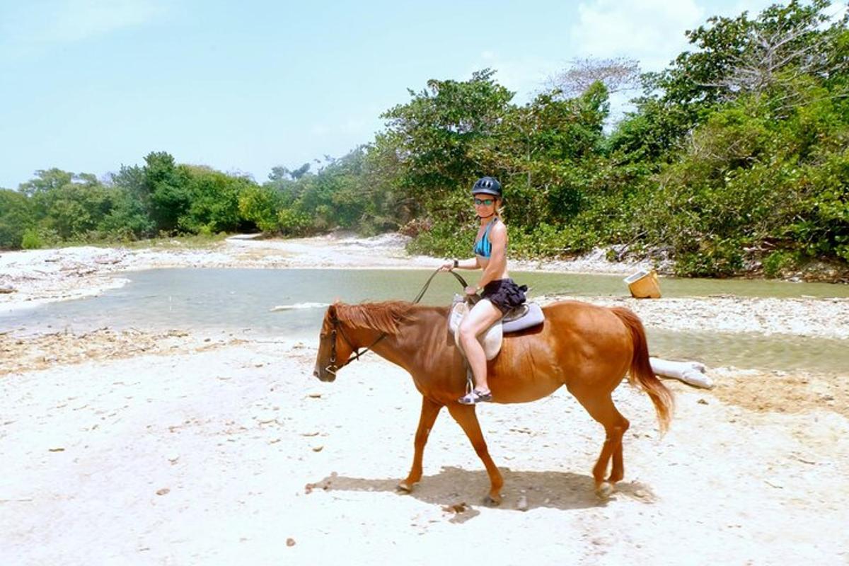 Una joven montando a caballo en la playa