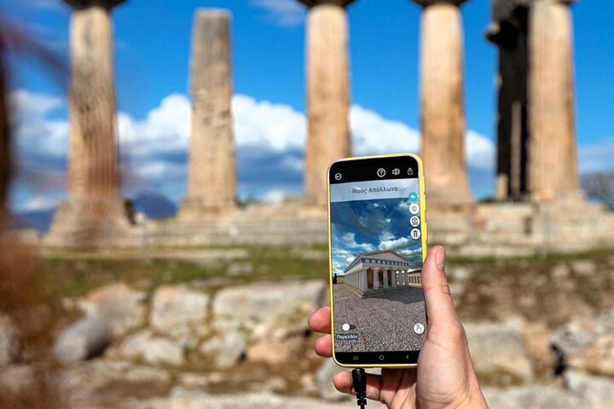 una persona che tiene in mano un telefono cellulare davanti ad alcune rovine